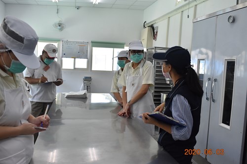 稽查員與作業同學討論各項食品衛生標準