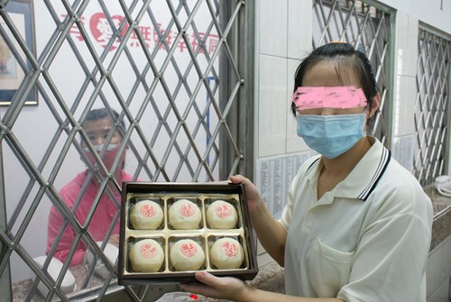 小萱透過窗口向家人展示充滿愛心的綠豆椪